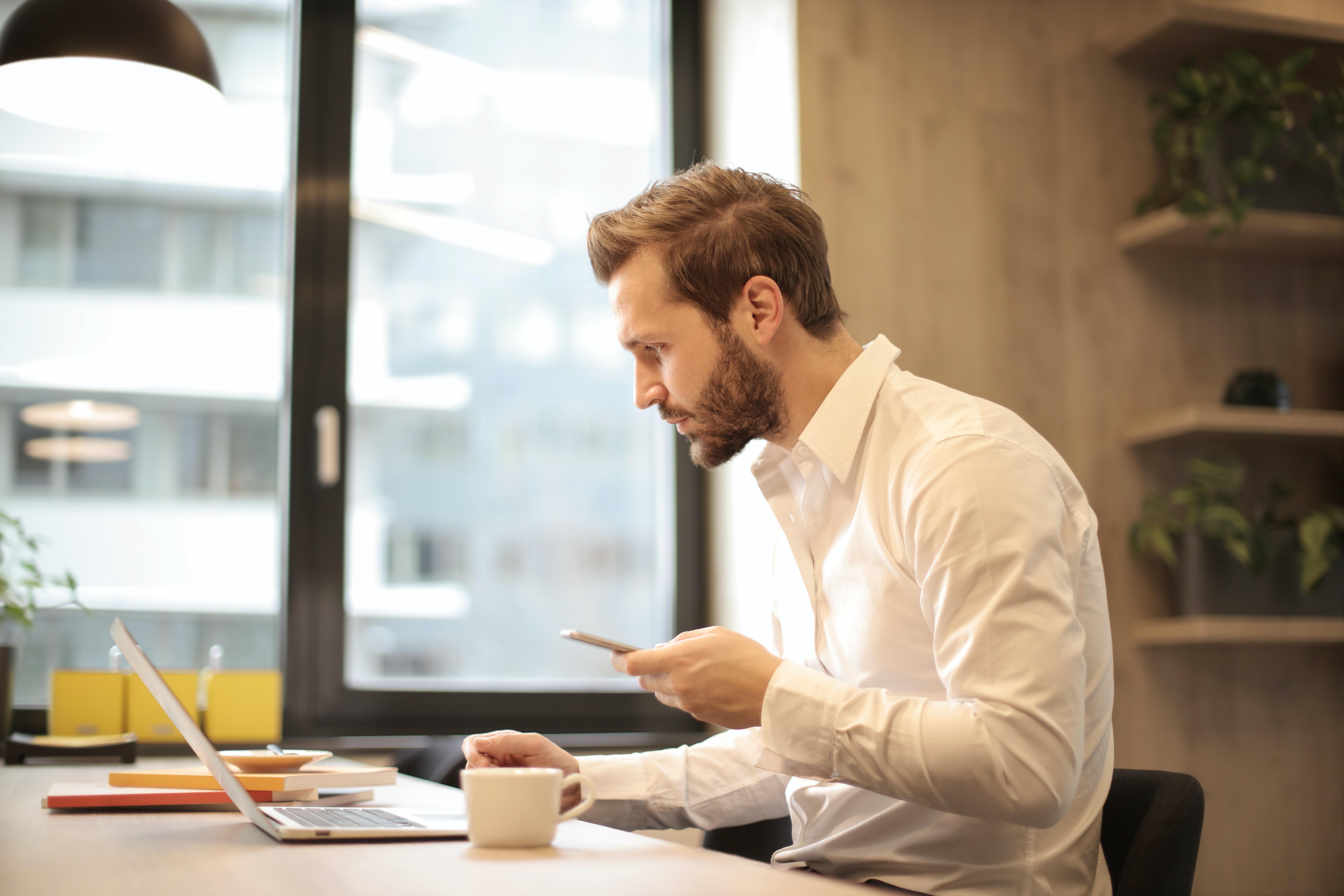 A business man working at his laptop while sipping some coffee